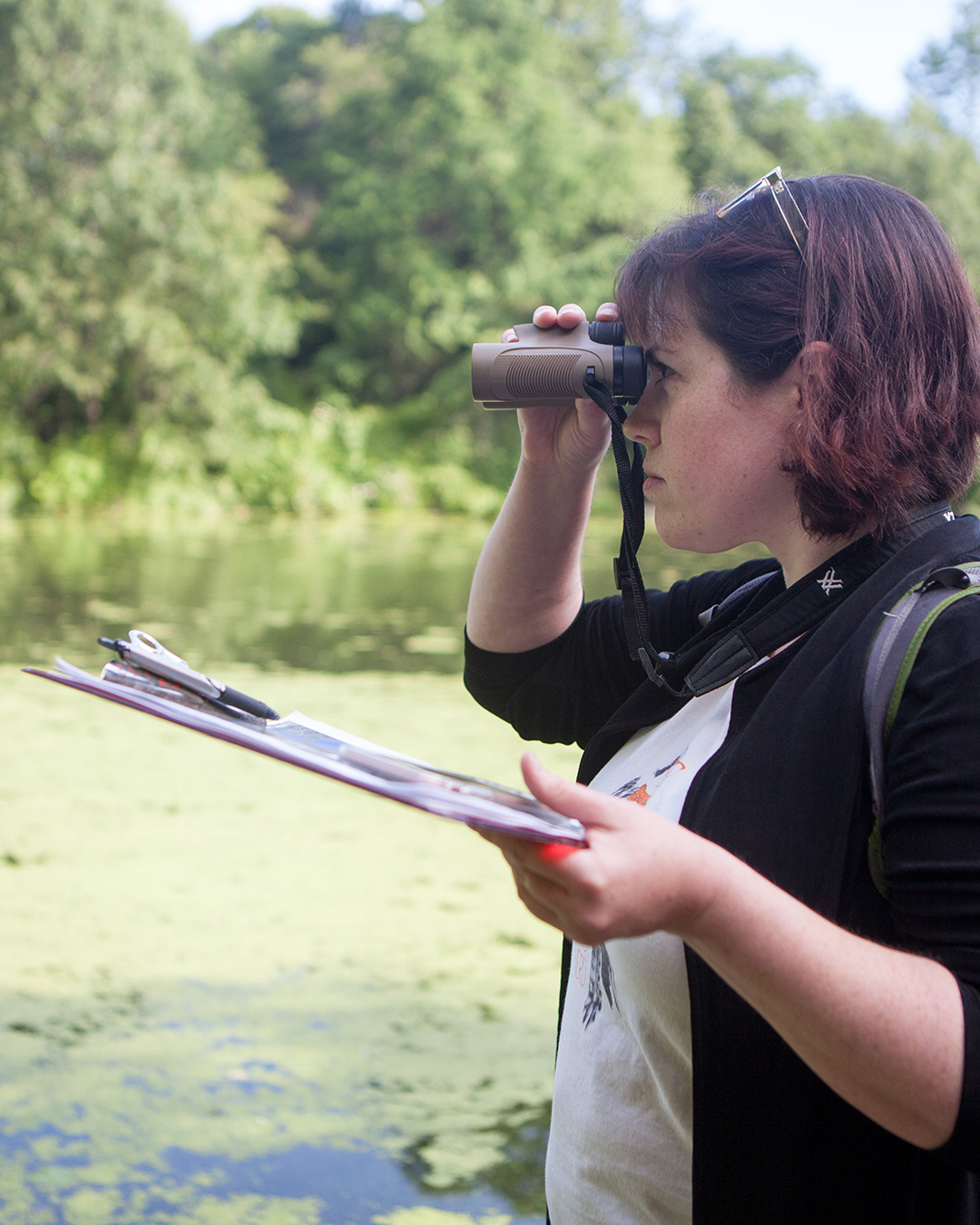 Someone participating in the Climate Watch with a clipboard and binoculars